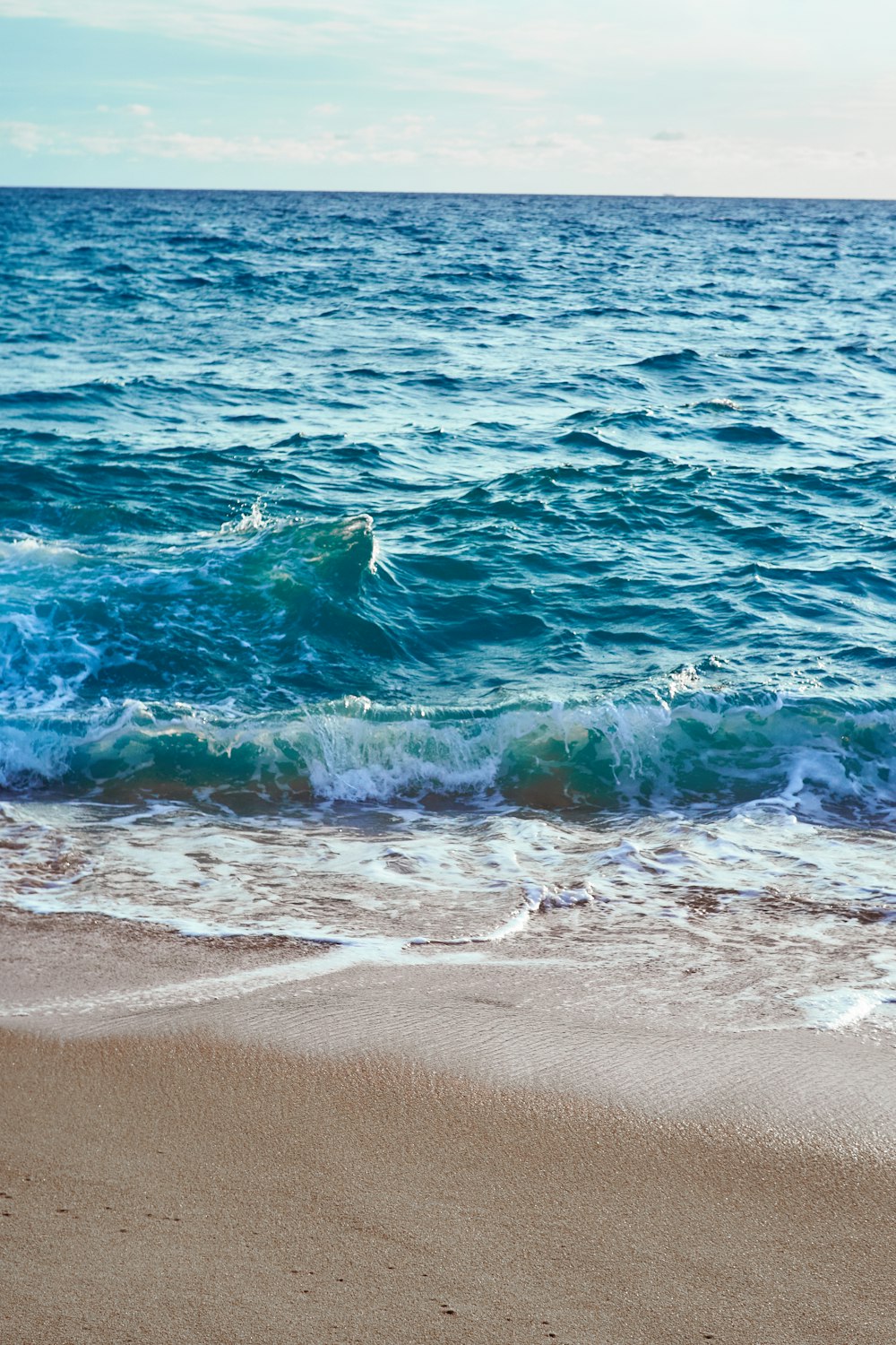 sea waves crashing on shore during daytime