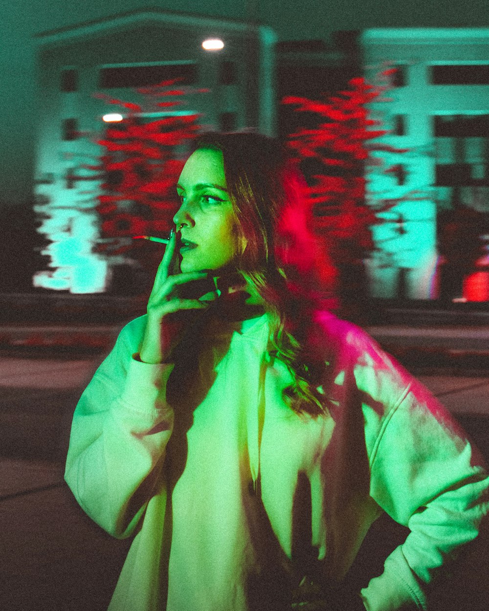 woman in white robe standing on street during night time