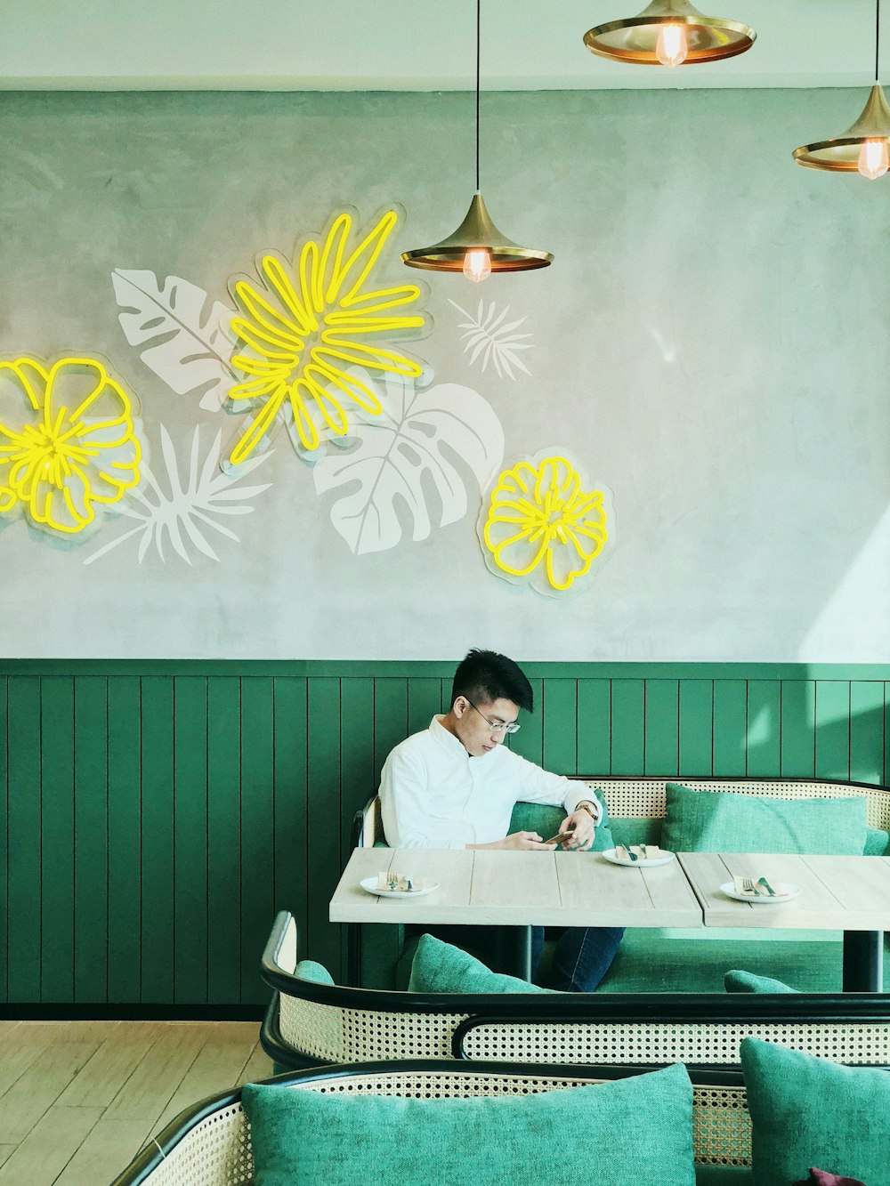 man in white dress shirt sitting on green bench