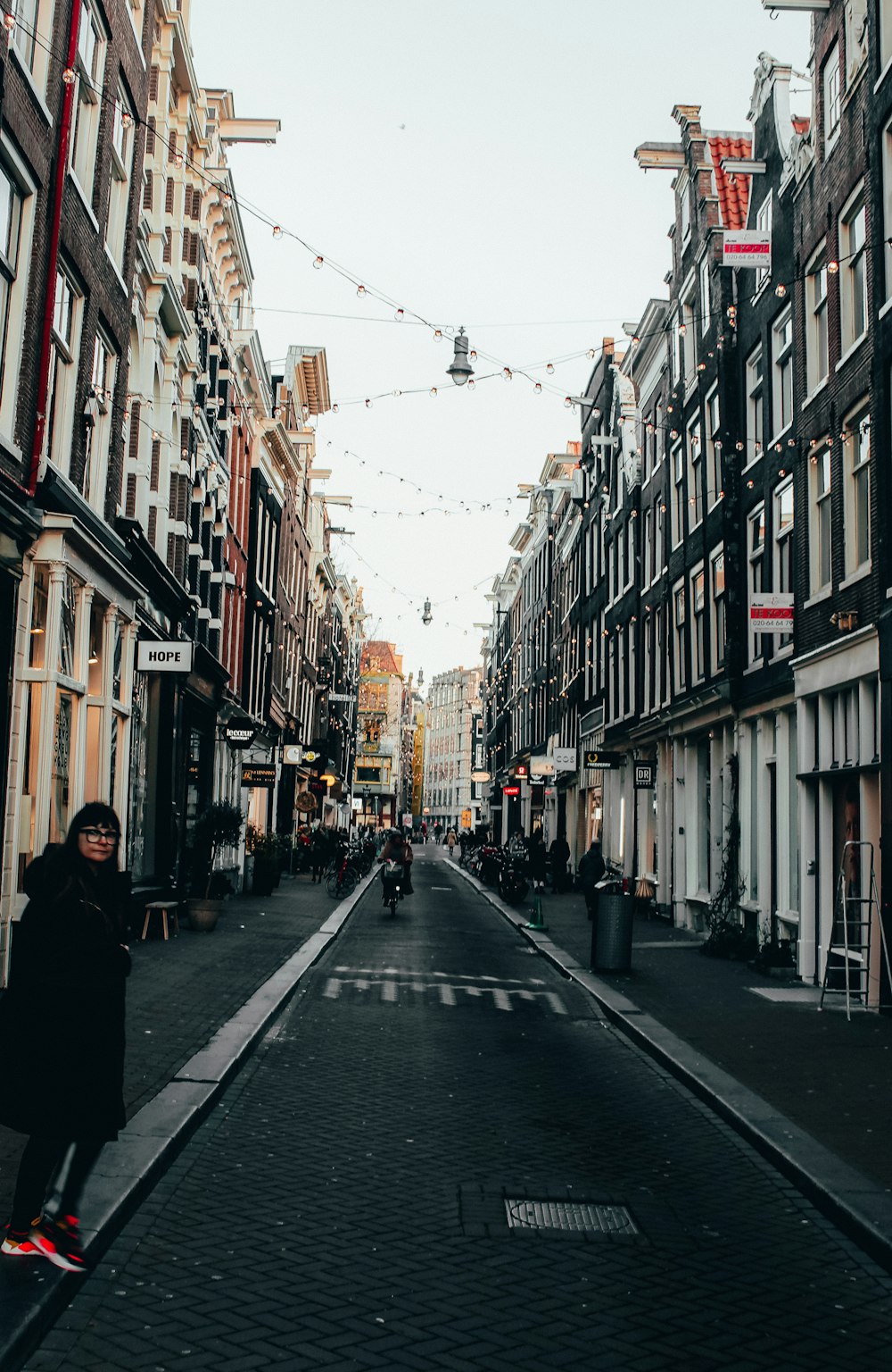 persone che camminano per strada tra gli edifici durante il giorno