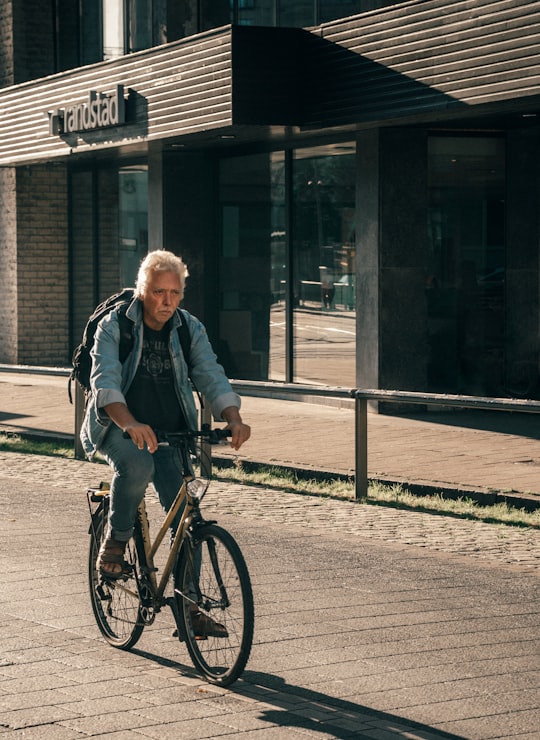 woman in black jacket riding on bicycle in Antwerpen Belgium