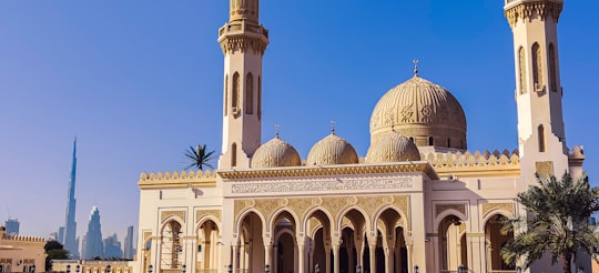 white and brown concrete building under blue sky during daytime in Zabeel Masjid United Arab Emirates