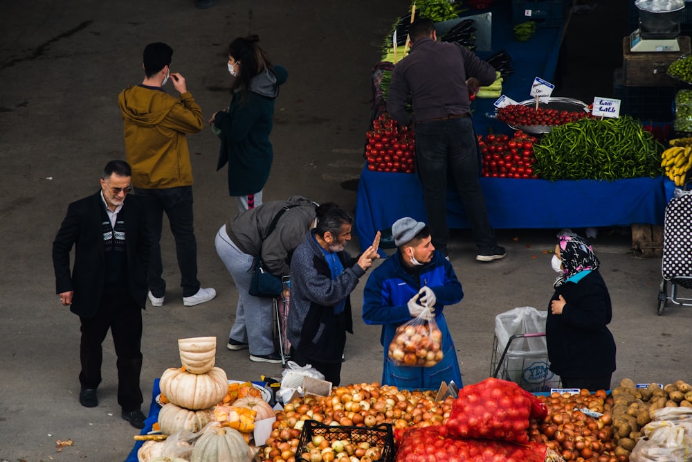 people standing on street with fruits and vegetables