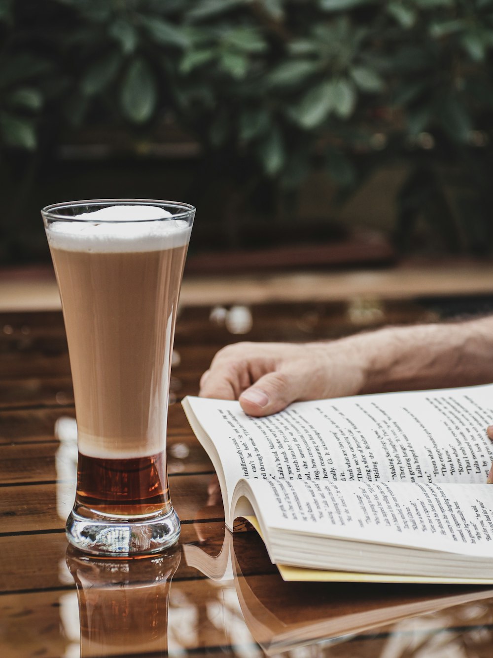 clear drinking glass with brown liquid on brown wooden table