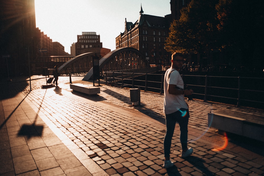 man and woman walking on sidewalk during daytime