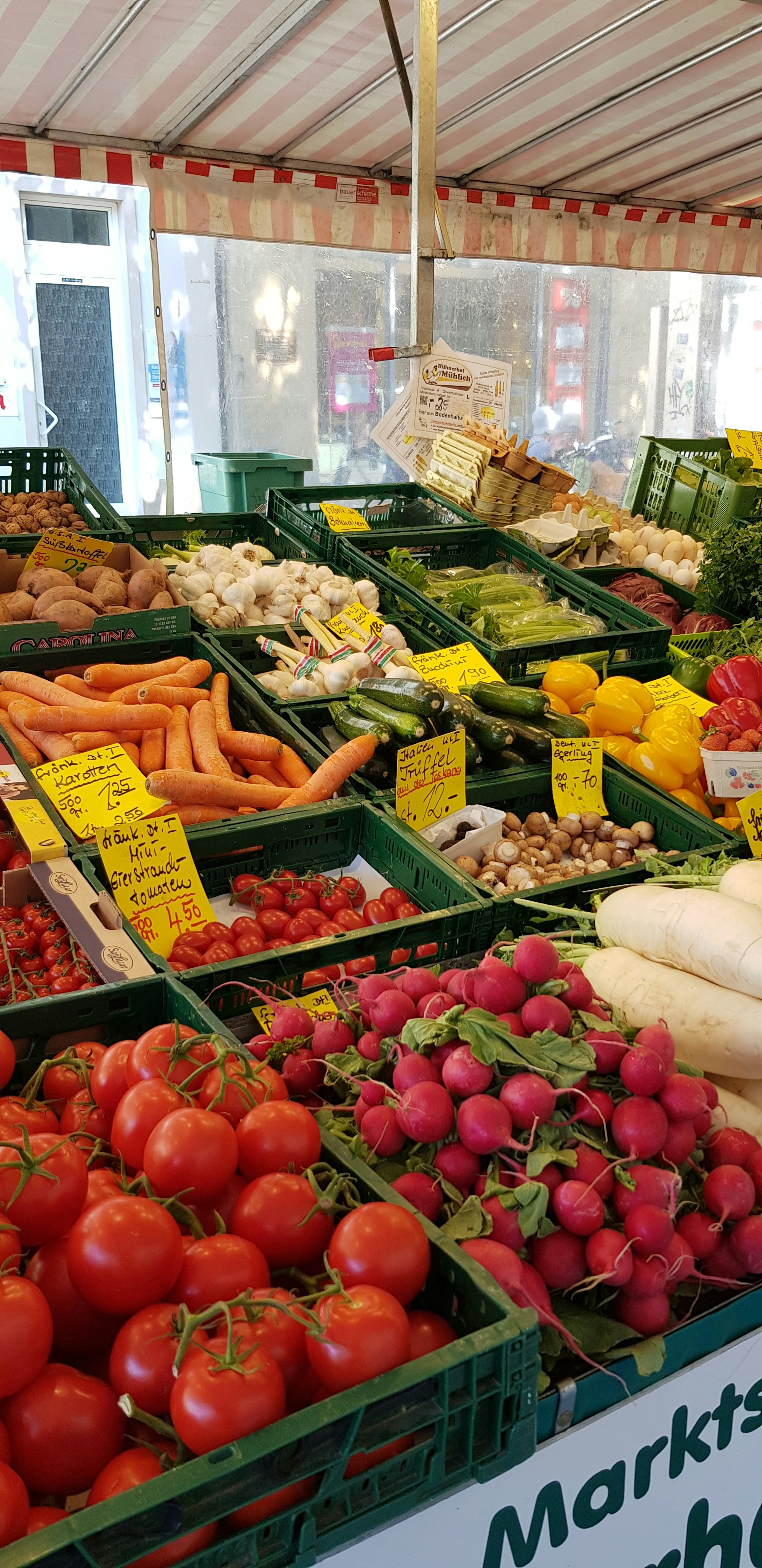 Fresh colorful vegetables and fruits arranged on market stall