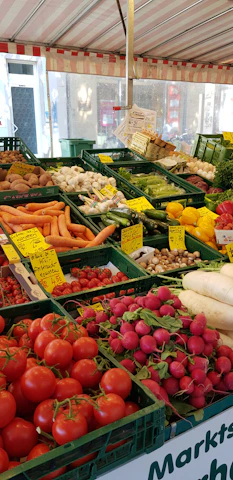 A vibrant display of fresh vegetables arranged at a bustling farmer's market stall.