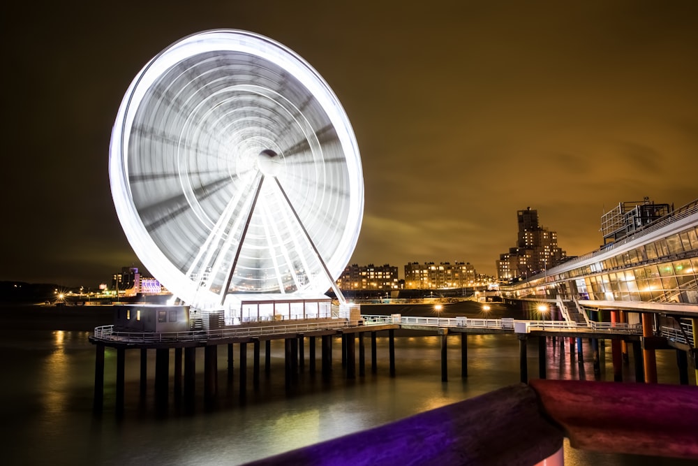 white ferris wheel near body of water during night time