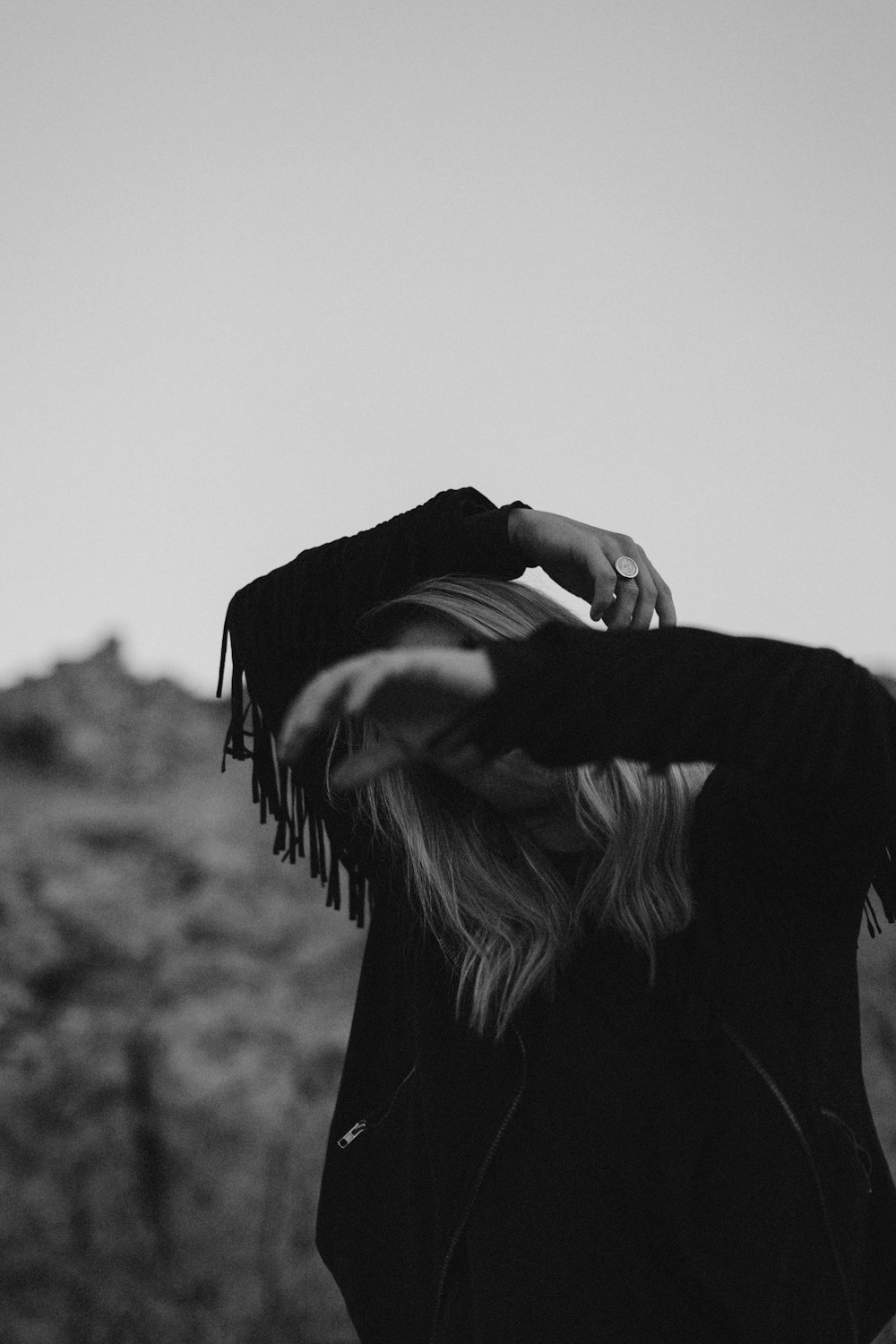 woman in black long sleeve shirt covering her face with her hands
