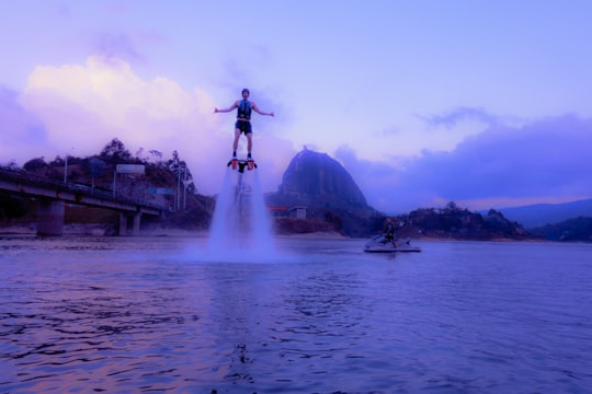 man standing on water fountain during daytime in Guatapé Colombia