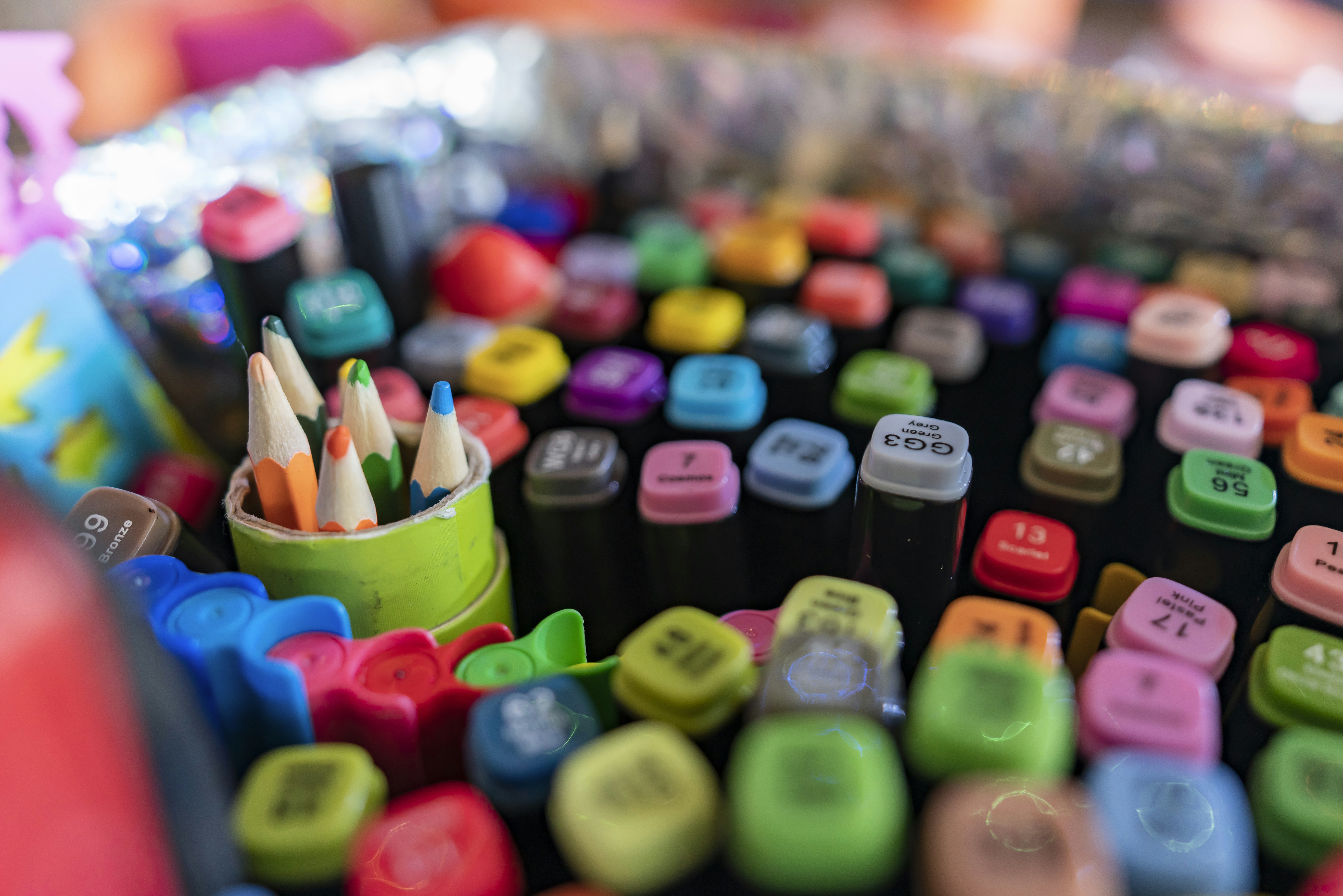 Colorful art markers and color pens arranged in a fan pattern on light background