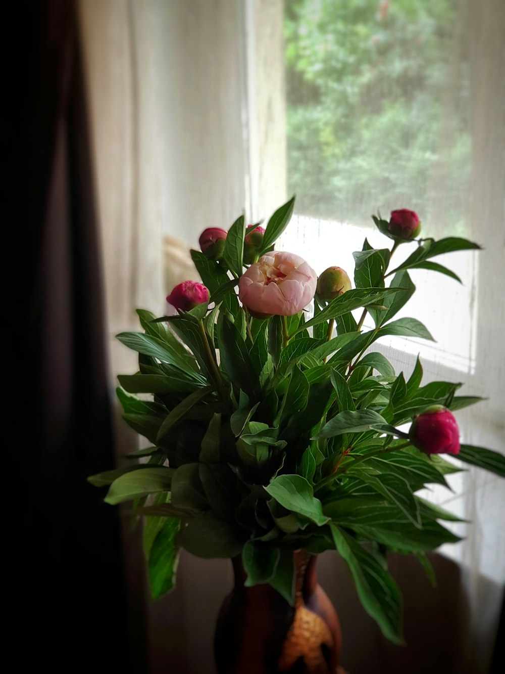 red and white roses in clear glass vase