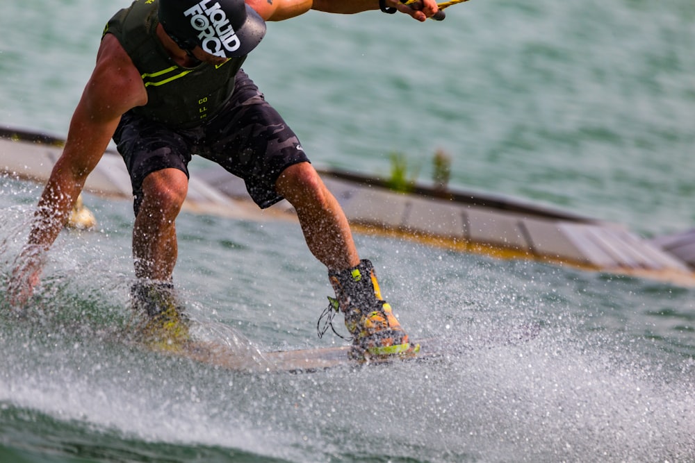 man in black and green tank top and shorts playing skateboard on water  during daytime photo – Free Image on Unsplash