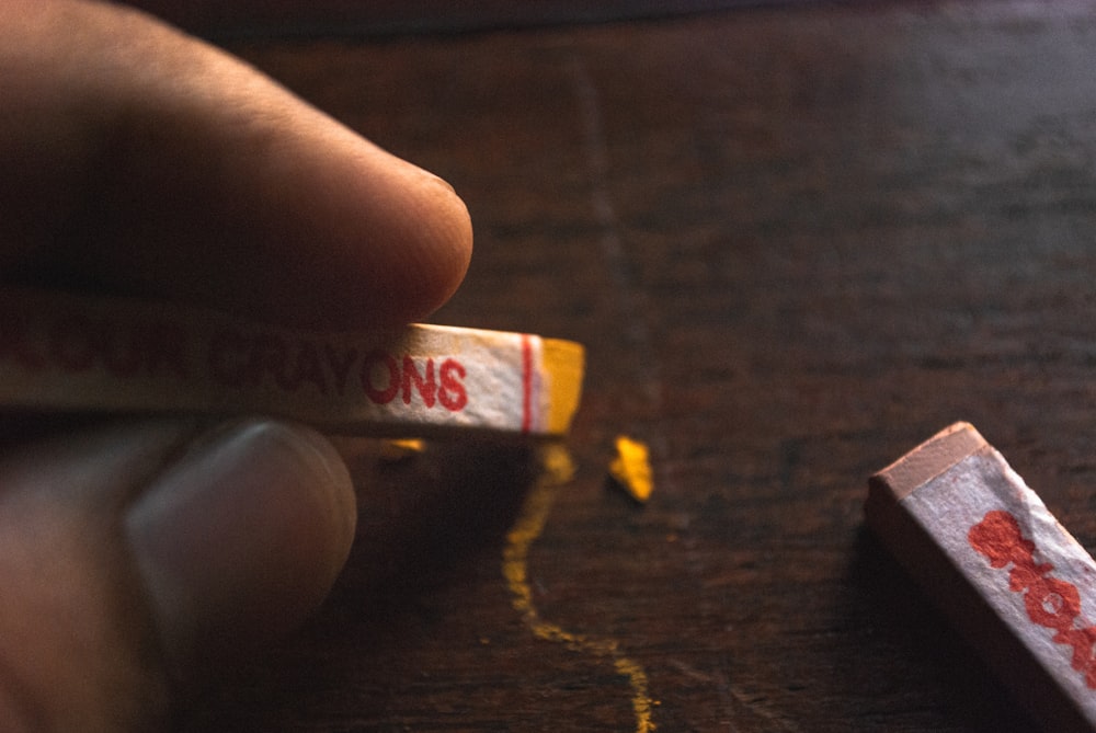 person holding red and white labeled box