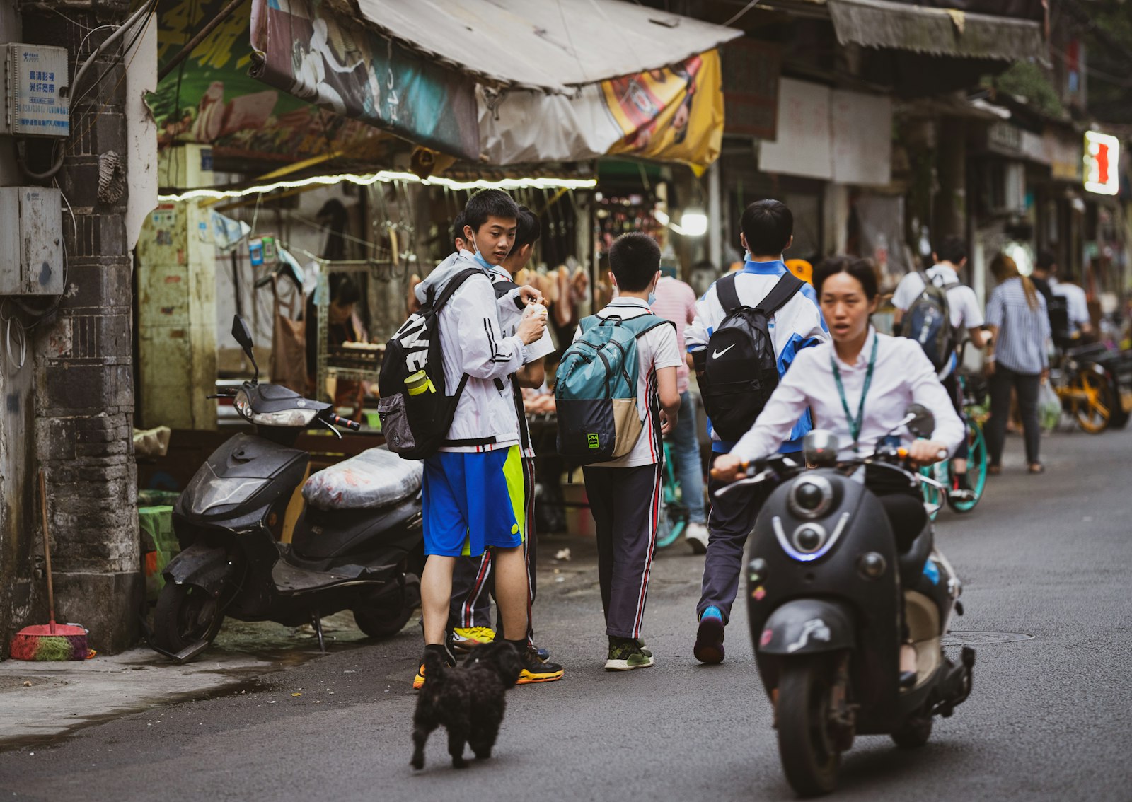 Sony FE 135mm F1.8 GM sample photo. People walking on street photography