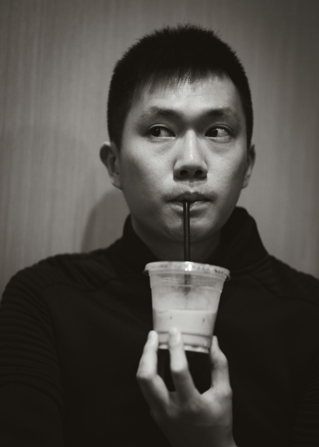 man in black shirt drinking from clear plastic cup