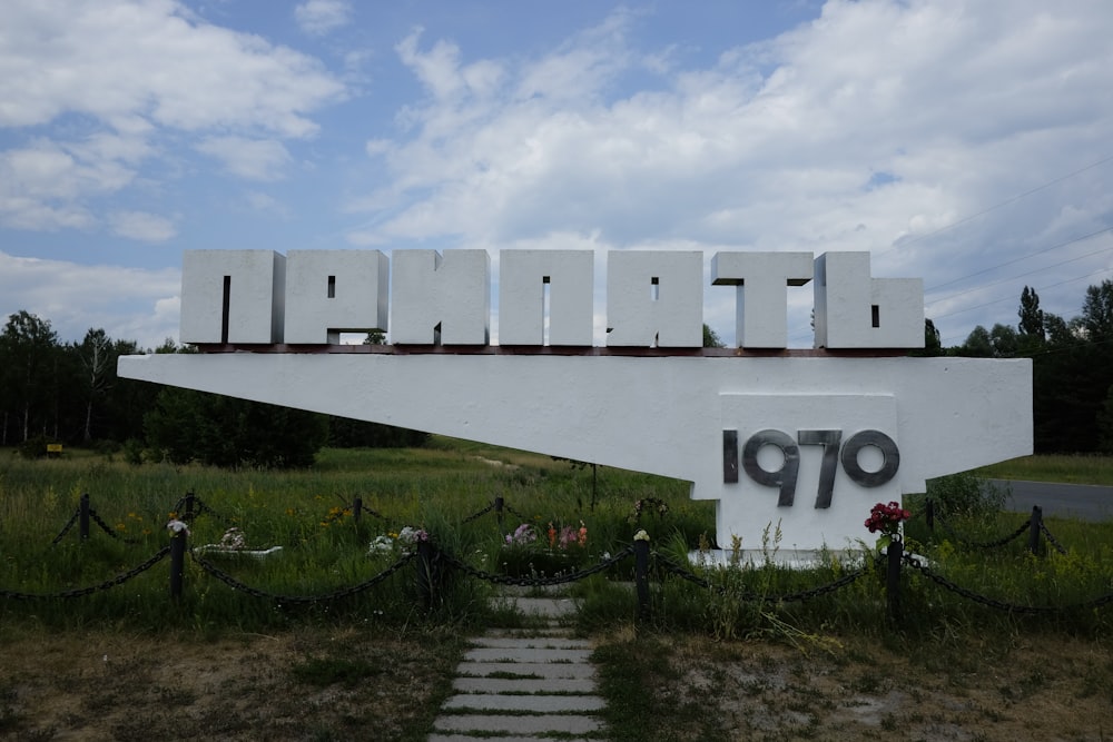 white concrete building near green grass field under white clouds during daytime