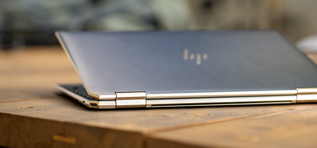 silver macbook on brown wooden table