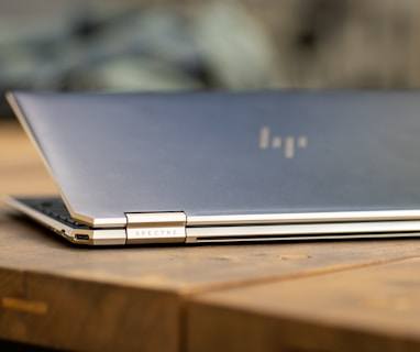 silver macbook on brown wooden table