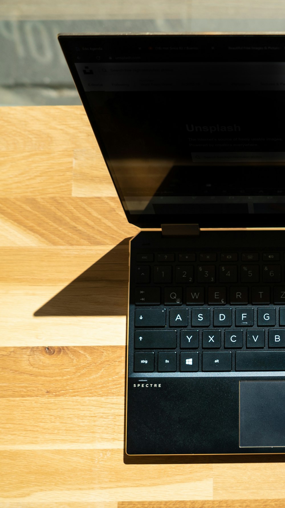 Computadora portátil negra sobre mesa de madera marrón