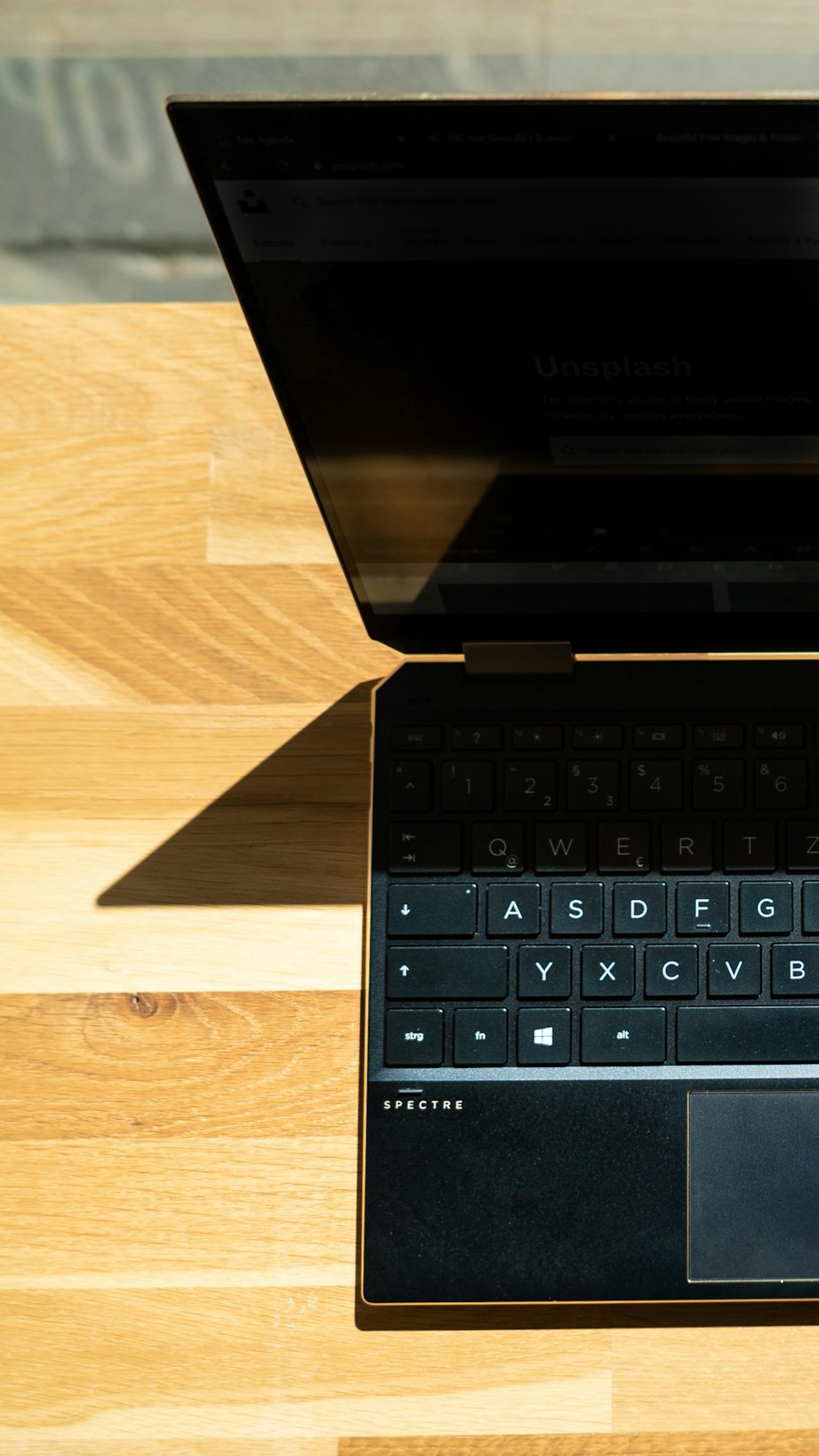 black laptop computer on brown wooden table