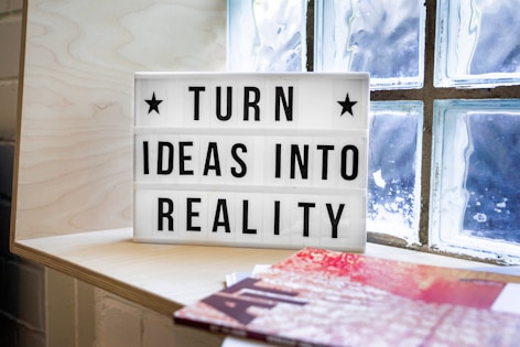 white and black wooden quote board with quote: turn ideas into reality