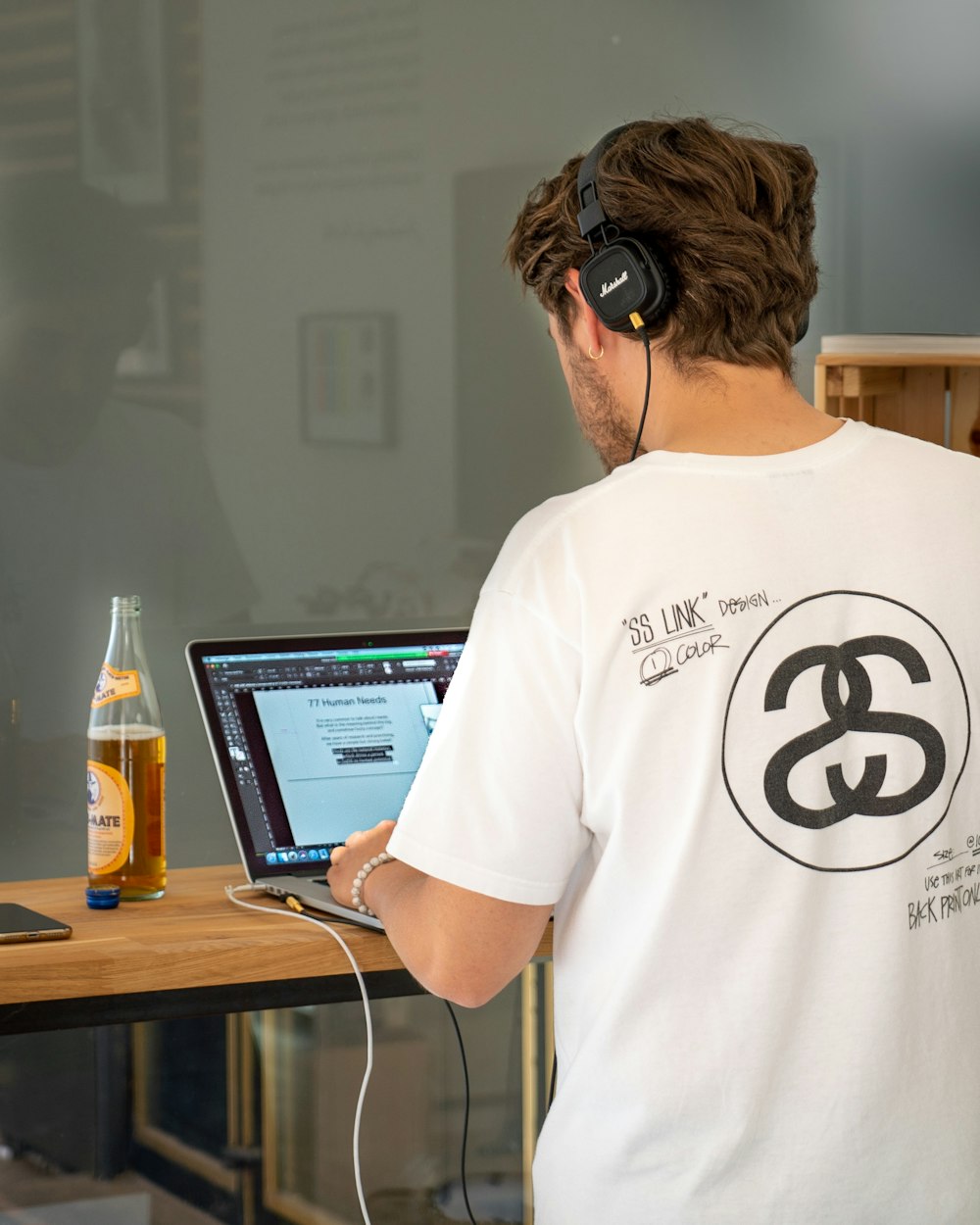 man in white crew neck t-shirt wearing black headphones