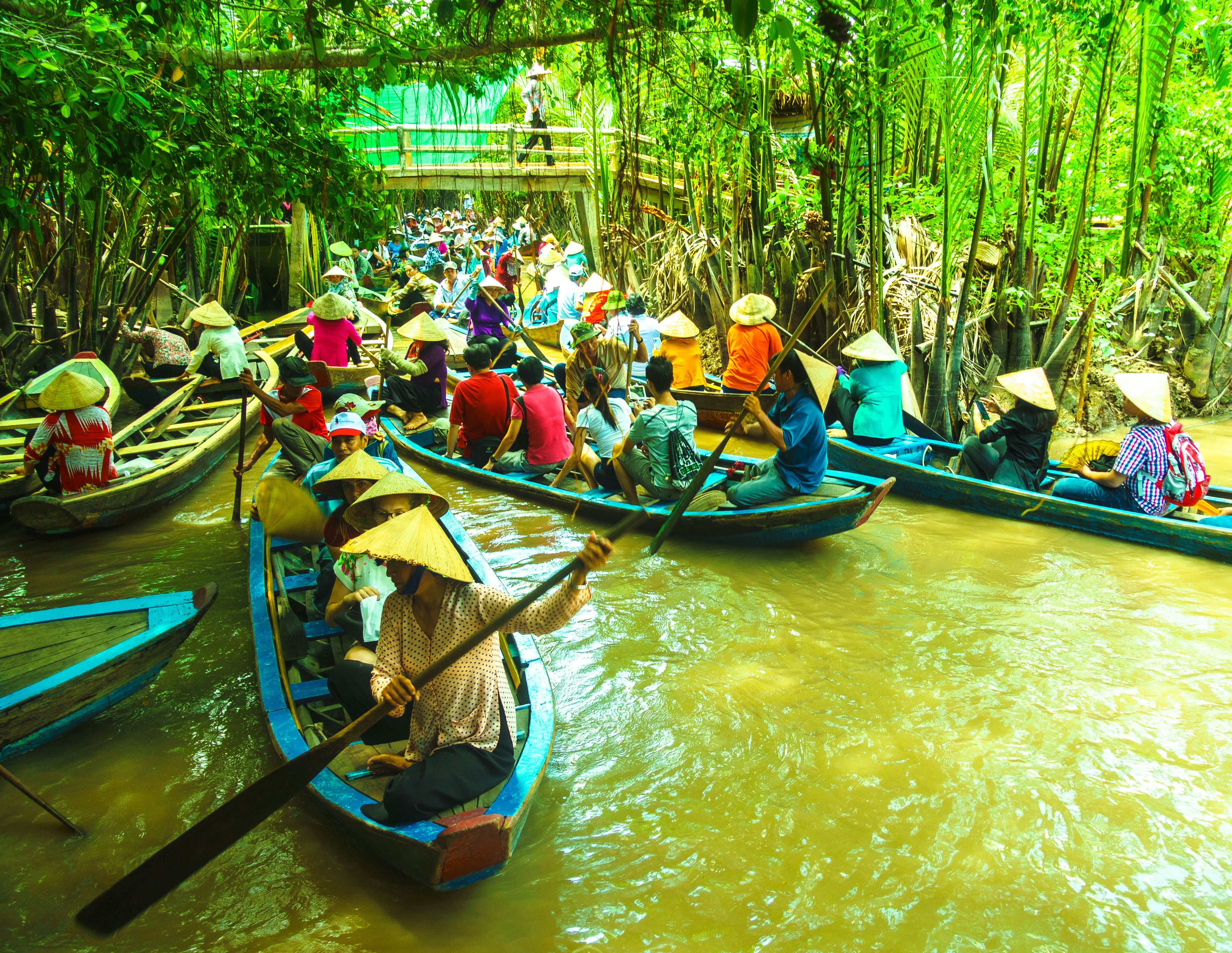 people riding on boat on river during daytime, A crowded Mekong River in Vietnam.