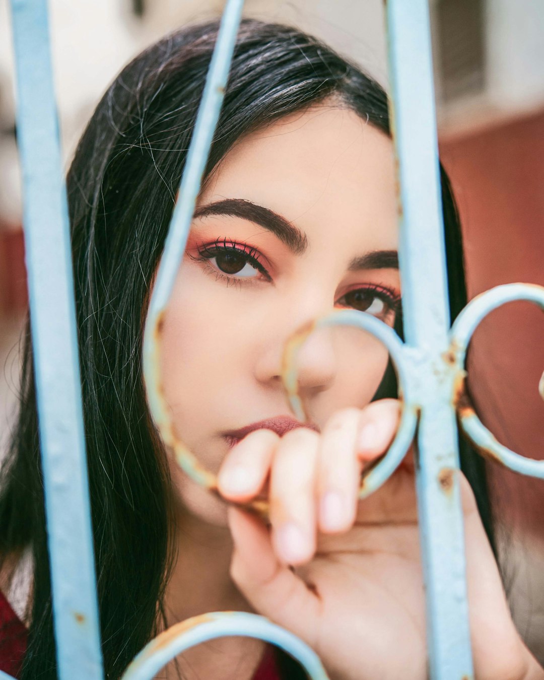 woman in white shirt holding on white metal fence