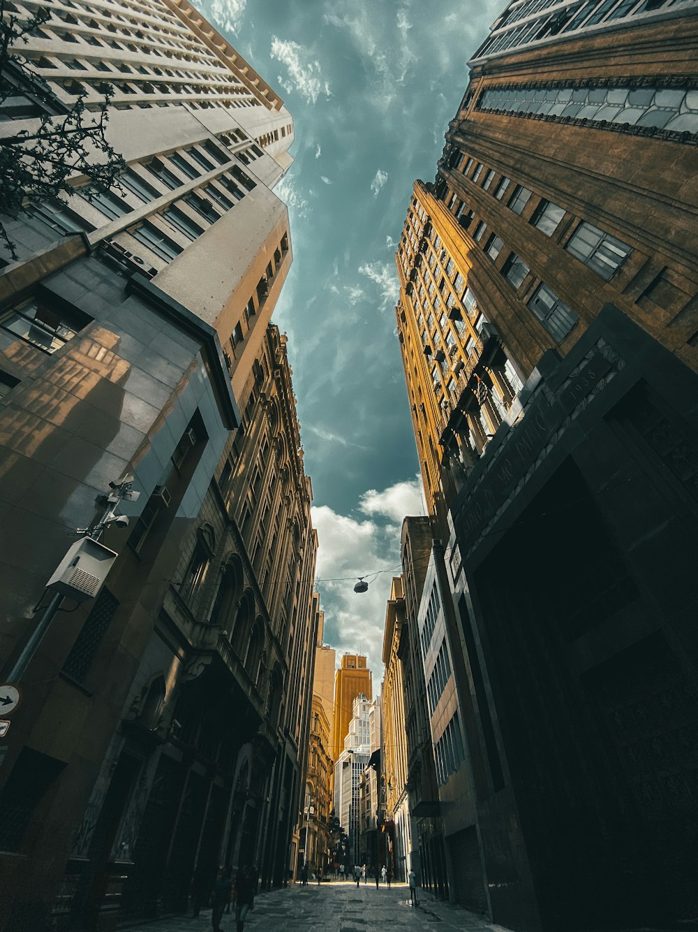 low angle photography of brown concrete building under white clouds and blue sky during daytime