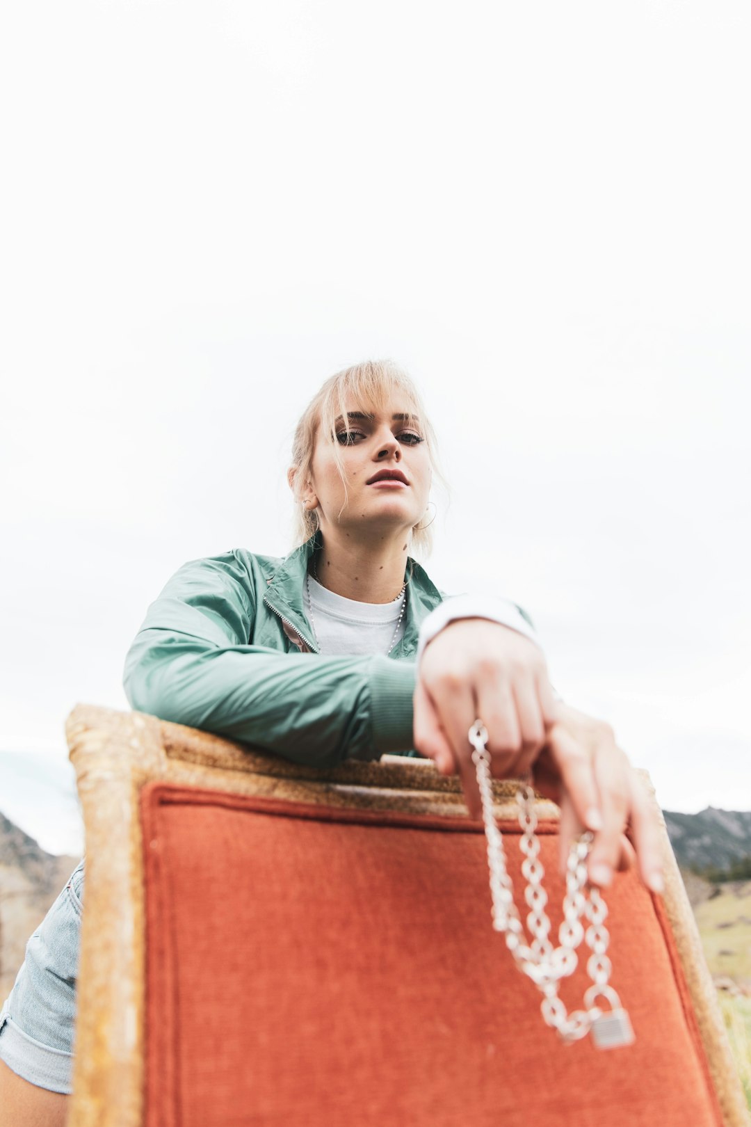 woman in green hoodie sitting on brown wooden chair