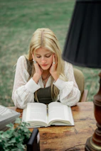 woman in white long sleeve shirt reading book