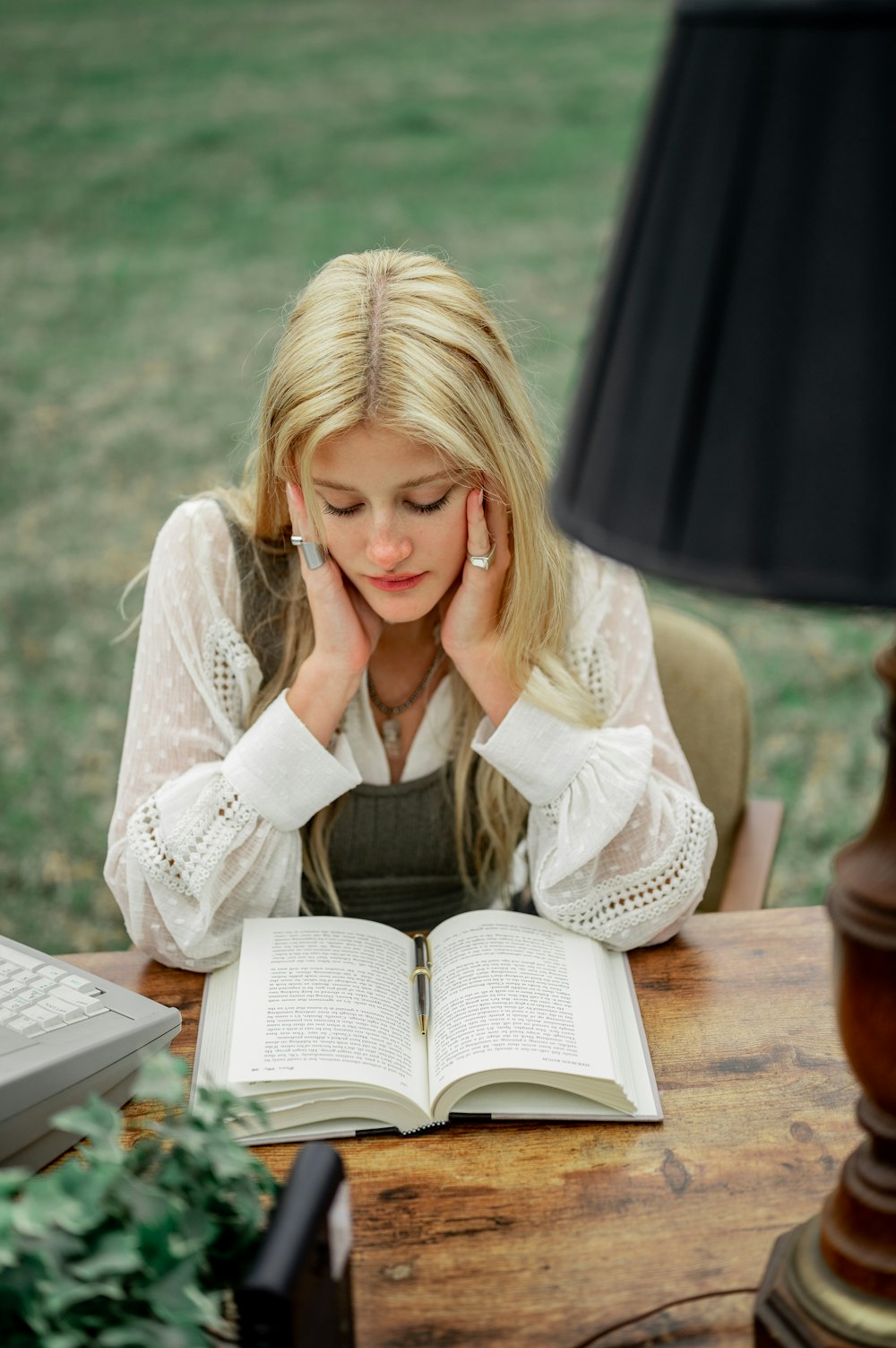 woman in white long sleeve shirt reading book