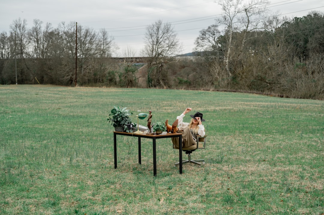 people sitting on brown wooden picnic table on green grass field during daytime