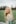 woman in white lace shirt standing on green grass field during daytime