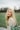 woman in white lace shirt standing on green grass field during daytime