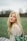 woman in white lace shirt standing on green grass field during daytime