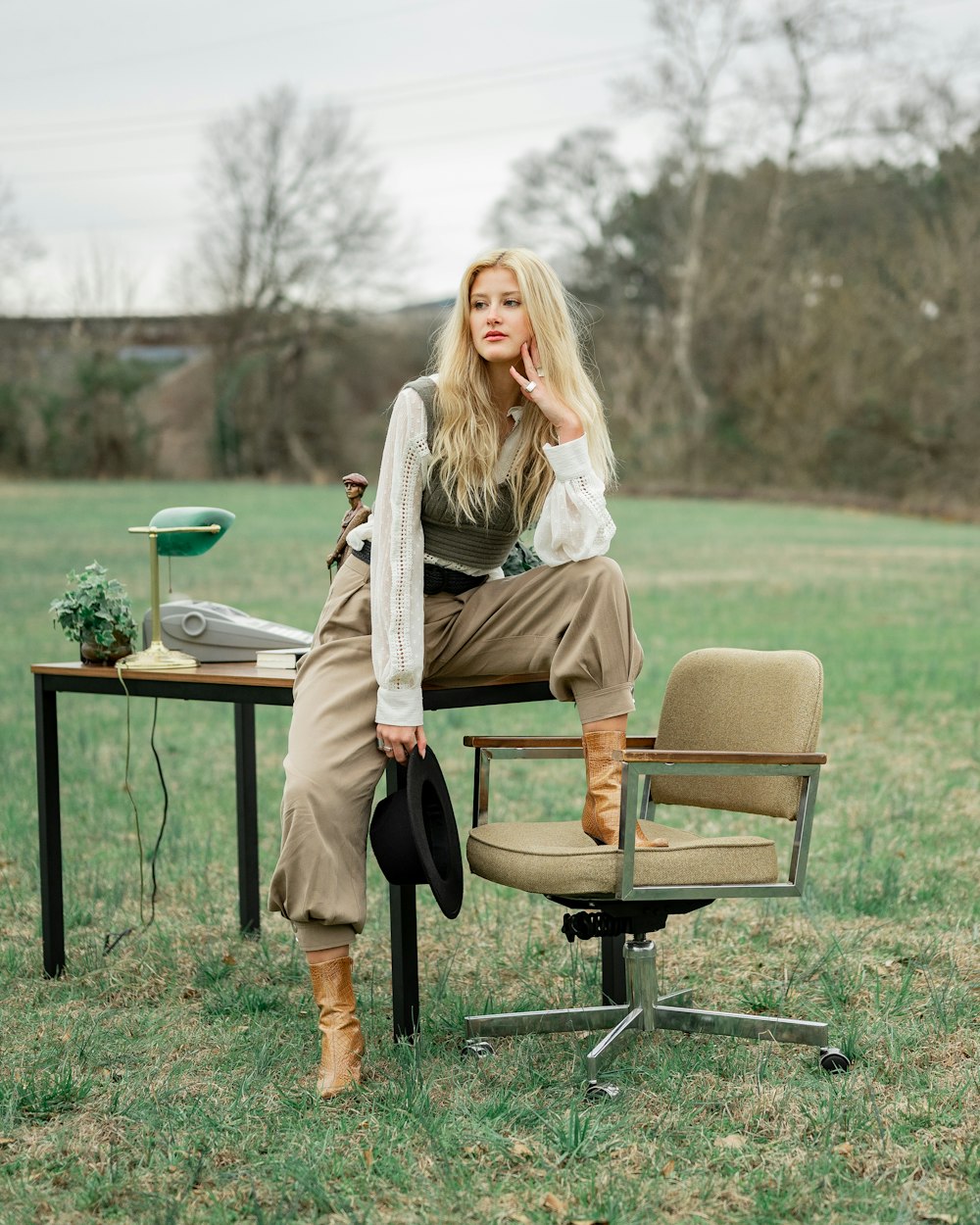 woman in gray coat sitting on brown and black chair