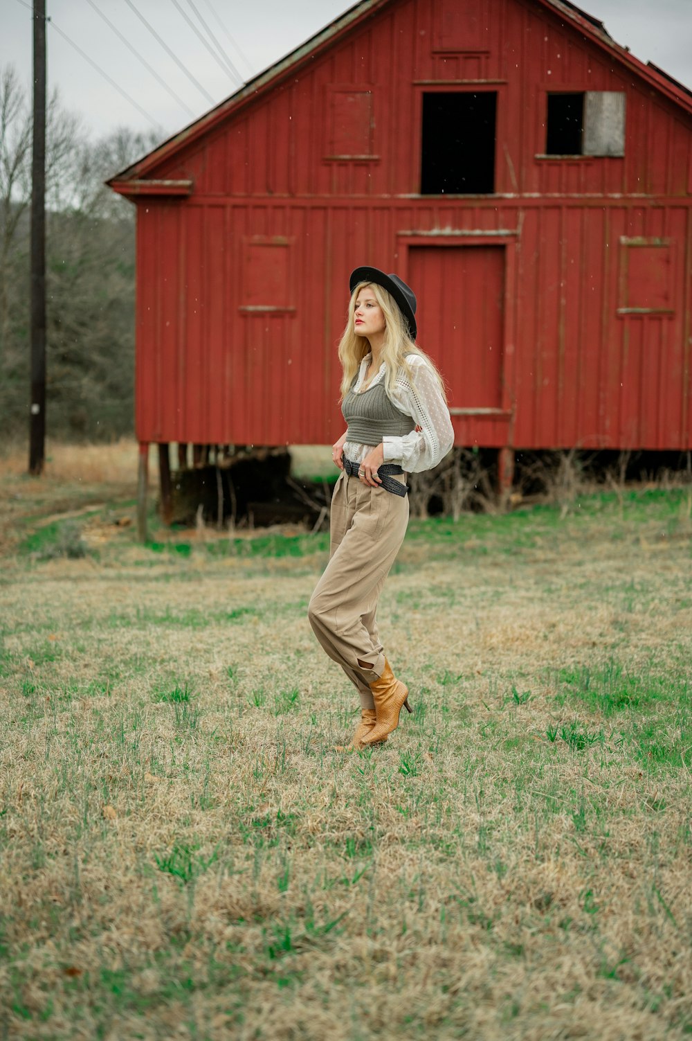 woman in white long sleeve shirt and brown pants standing on green grass field during daytime