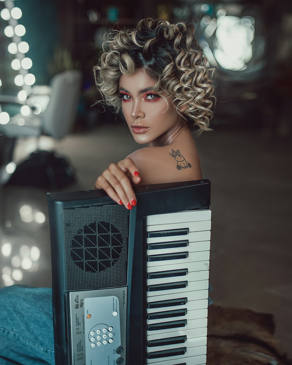 woman in black tube top holding gray and black electronic keyboard