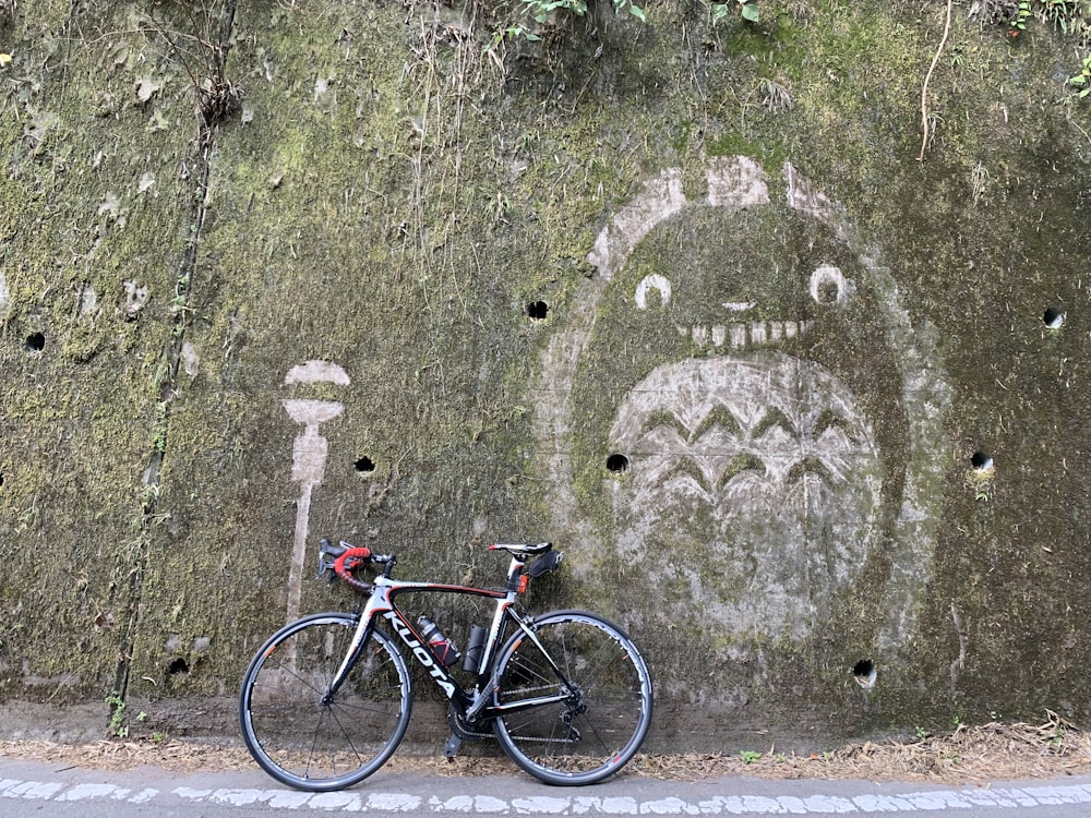 black and red mountain bike leaning on wall