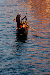 Elegant skipper guiding a sleek boat on calm waters of Lake Maggiore at sunset.