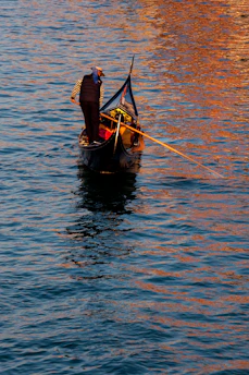Elegant skipper guiding a sleek boat on calm waters of Lake Maggiore at sunset.
