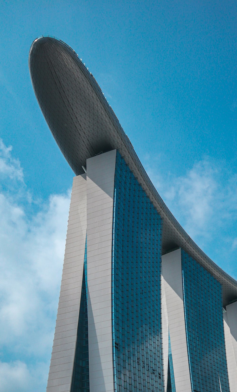 edifício de concreto branco e azul sob o céu azul durante o dia