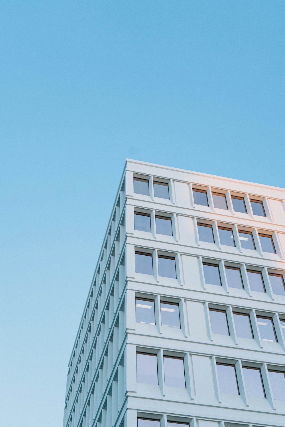 Edificio de hormigón blanco bajo el cielo azul durante el día