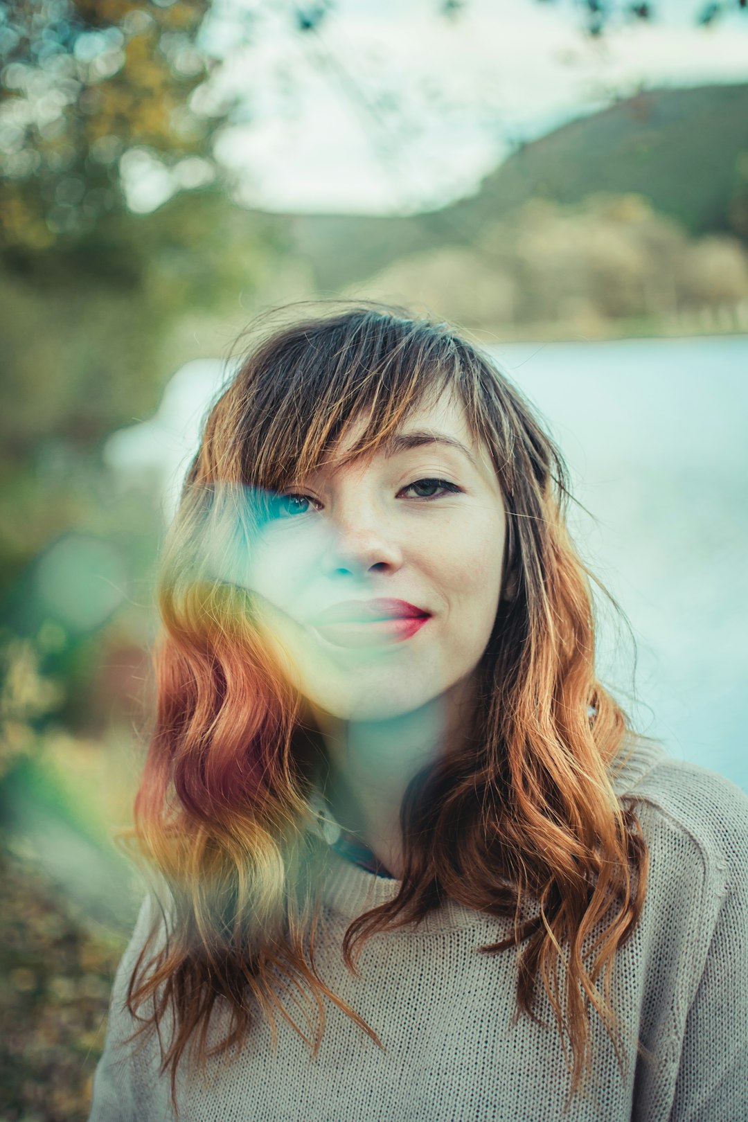 girl in gray sweater with rainbow on her face