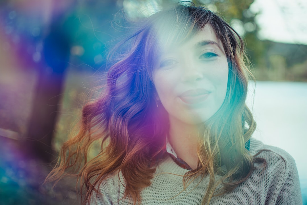 woman in white knit shirt with blue hair