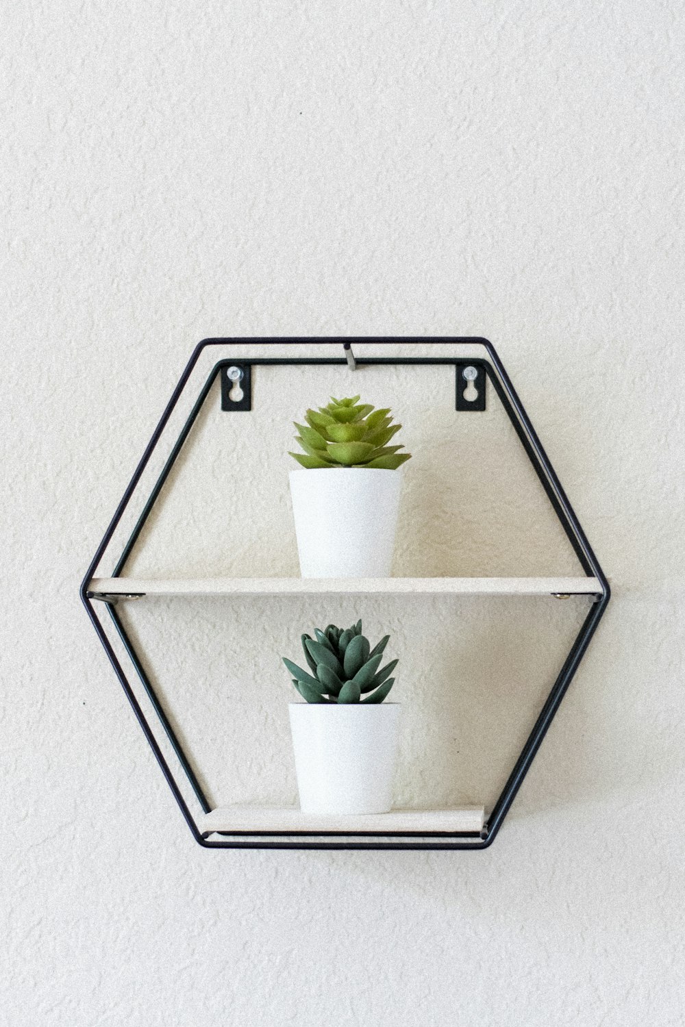 white flower in white ceramic pot on gray metal rack