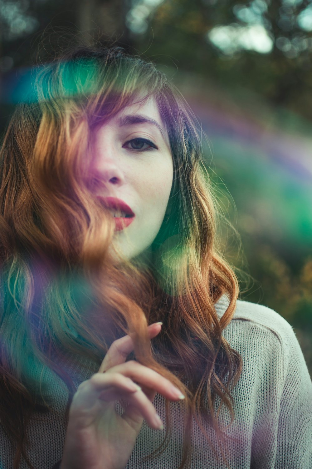 woman in white sweater with green and brown hair