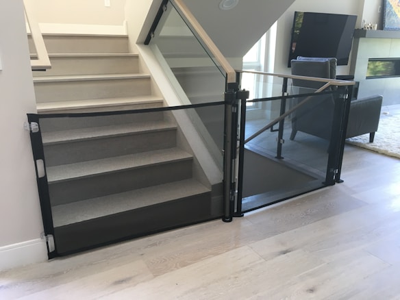 Parents gently installing a baby gate in a stylish modern home.